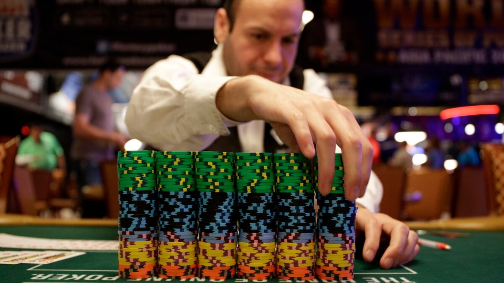 A man in a Casino arranging casino chips